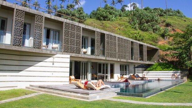 A modern hotel with a swimming pool, outdoor seating, and a view of palm trees. - Modern Beach Villa With Roof Garden (Talalla)