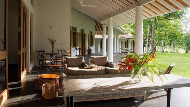 A covered outdoor seating area with a sofa, chairs, and a table. - Family House With Large Garden In A Peaceful Setting (Padinnoruwa)