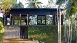 A modern house with a flat roof, large windows, and a covered outdoor area. - Historically Important Architecturally Stunning Hilltop Villa (Hapugala)