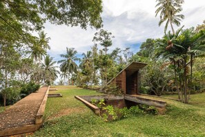 Stroll through the lush garden, surrounded by tropical plants and palm trees, and enjoy the patio area with a brick structure.