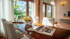 A wooden dining table with a book and a floral arrangement. - Primula apartment (Città metropolitana di Firenze)