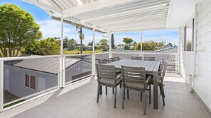 Un balcon abrité, doté d’une table et de chaises, qui offre une vue sur le quartier.