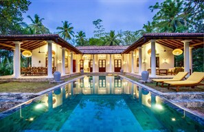 Relax by the central pool surrounded by a covered veranda with comfortable seating.