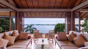 A room with a view of a lake, furnished with sofas and chairs, and a table with decorative items. - Elevated Villa Overlooking Tranquil Koggala Lake (Ahangama)