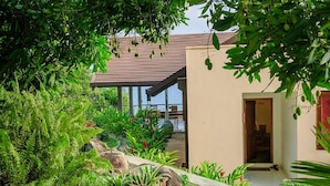 A modern house with a covered patio, lush greenery, and a view of the sea. - Elevated Villa Overlooking Tranquil Koggala Lake (Ahangama)