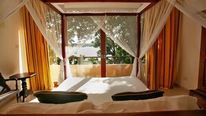 A bedroom with a bed, curtains, and a view of trees. - Elevated Villa Overlooking Tranquil Koggala Lake (Ahangama)