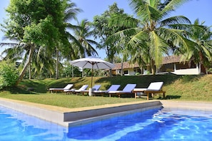A poolside area with lounge chairs and a palm tree. - Elevated Family Beach House With Ocean Views (Dikwella)