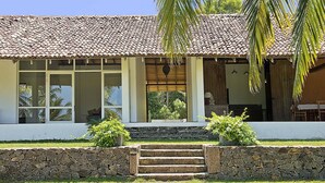 Una casa con techo de tejas, ventanas amplias y una pared de piedra frontal.