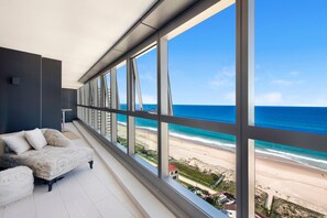A balcony with a view of the beach and ocean.