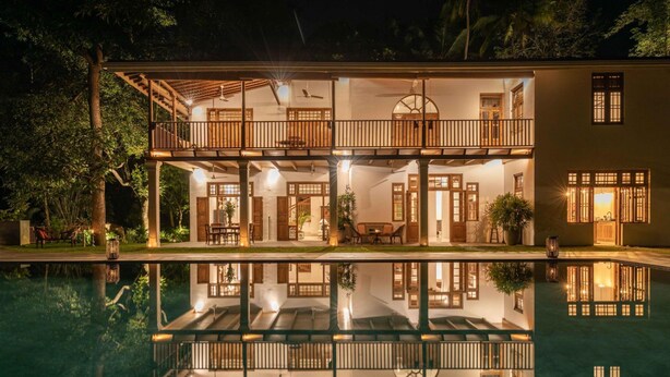 A two-story house with a balcony, a swimming pool, and a reflection of the house in the water. - Luxurious 07 Bedroom Hilltop Villa With Private Gym (Unawatuna)