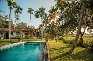 A pool surrounded by palm trees and a house with a tiled roof. - Antique Dutch Period Country House With Far Reaching West-facing Views (Unawatuna)