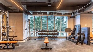 A gym with weightlifting equipment, benches, and dumbbells. - Modern & newly built studio Pool|Gym|Restaurant| (Miami)