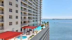 Un hôtel de grande hauteur doté de nombreux balcons, d’un espace piscine et offrant une vue sur la mer.