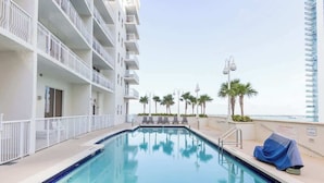 A rooftop pool with clear blue water, surrounded by white balconies and palm trees. - Ocean & City Views Lux Miami Brickell | Sleeps 5 (Miami)