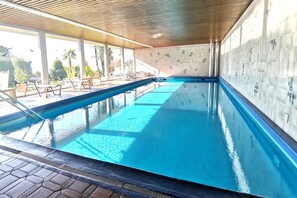 Una piscina al aire libre, una piscina climatizada