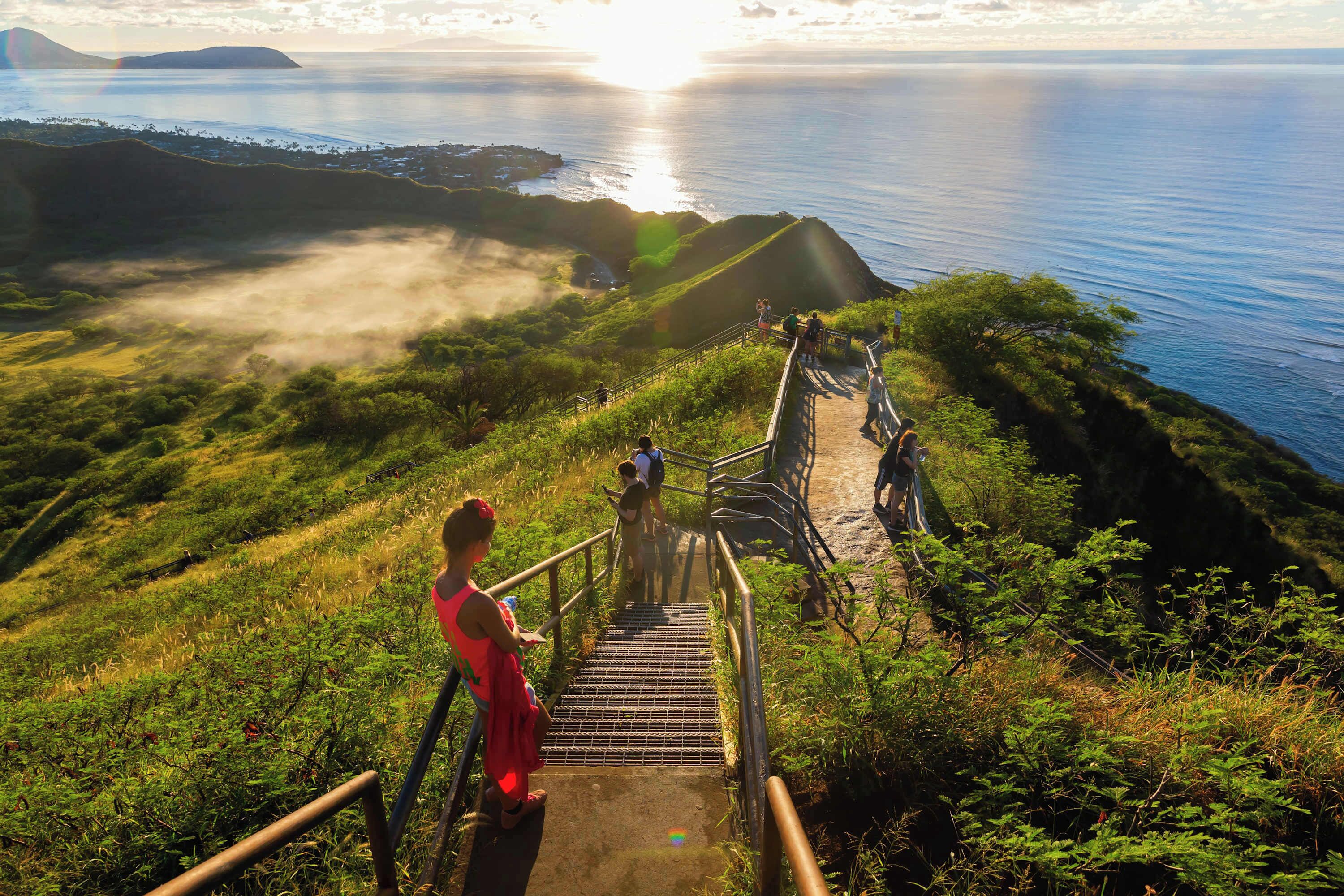 Una escalera que lleva a una zona costera con vistas al mar y una isla distante.