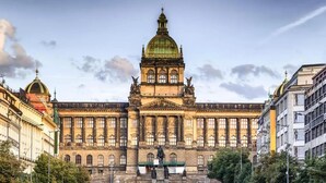 Ein großes, historisches Gebäude mit einer markanten Kuppel und Statuen davor.
