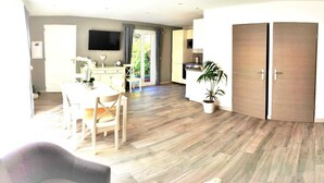 A spacious living area with a dining table, a sofa, and a kitchen in the background. - Escape near the sea (La Ciotat)