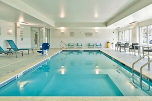 Una piscina con sillones de descanso y una estación de salvavidas.