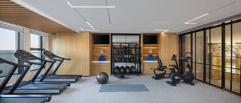 A modern gym with treadmills, exercise balls, and weight equipment.