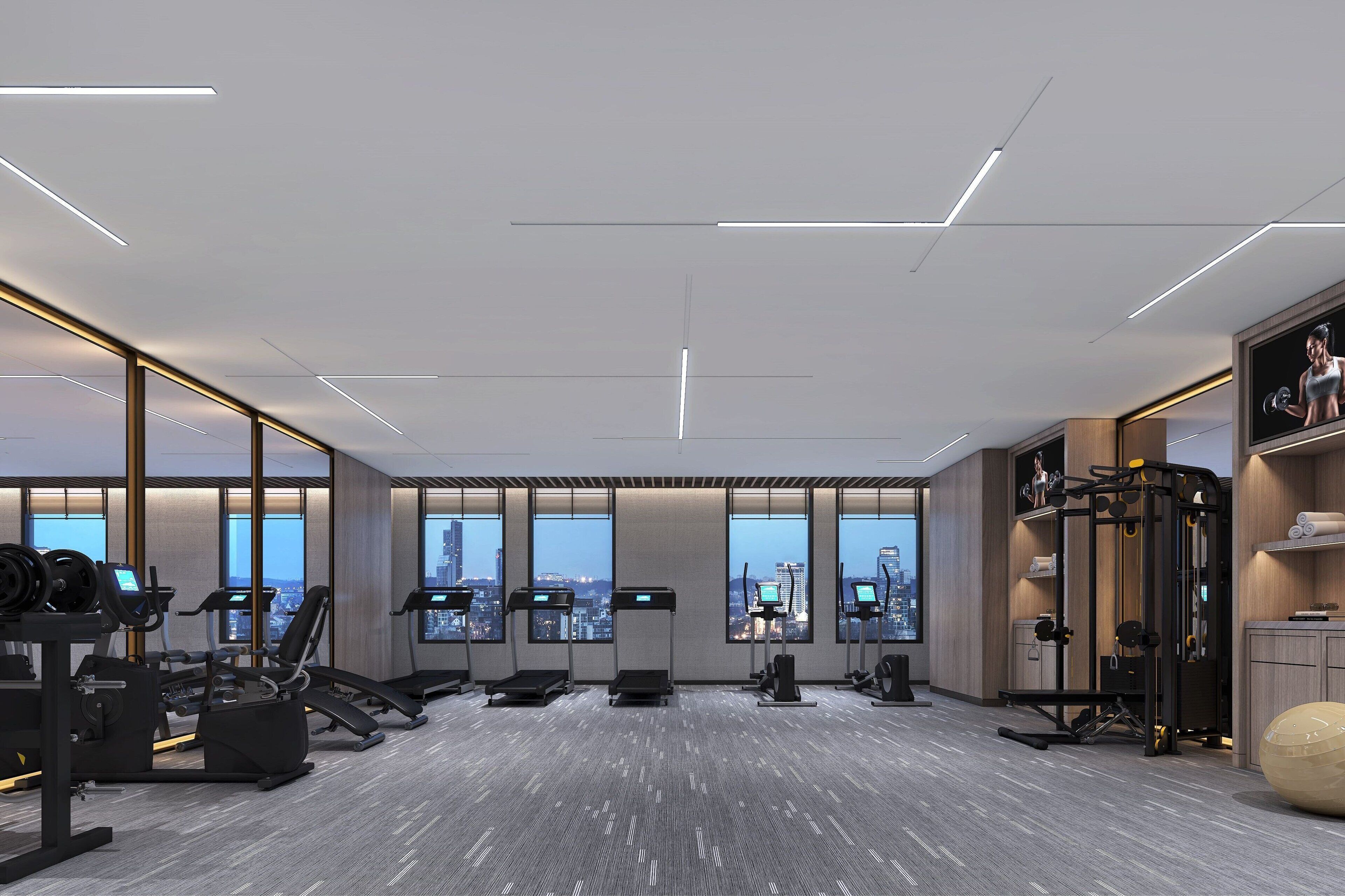 Un gimnasio moderno con máquinas de cardio, equipo de levantamiento de pesas y amplias ventanas con vistas a la ciudad.