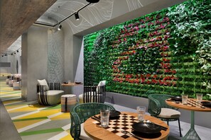 Un intérieur moderne avec un mur vert, des chaises à rayures et une table à carreaux.