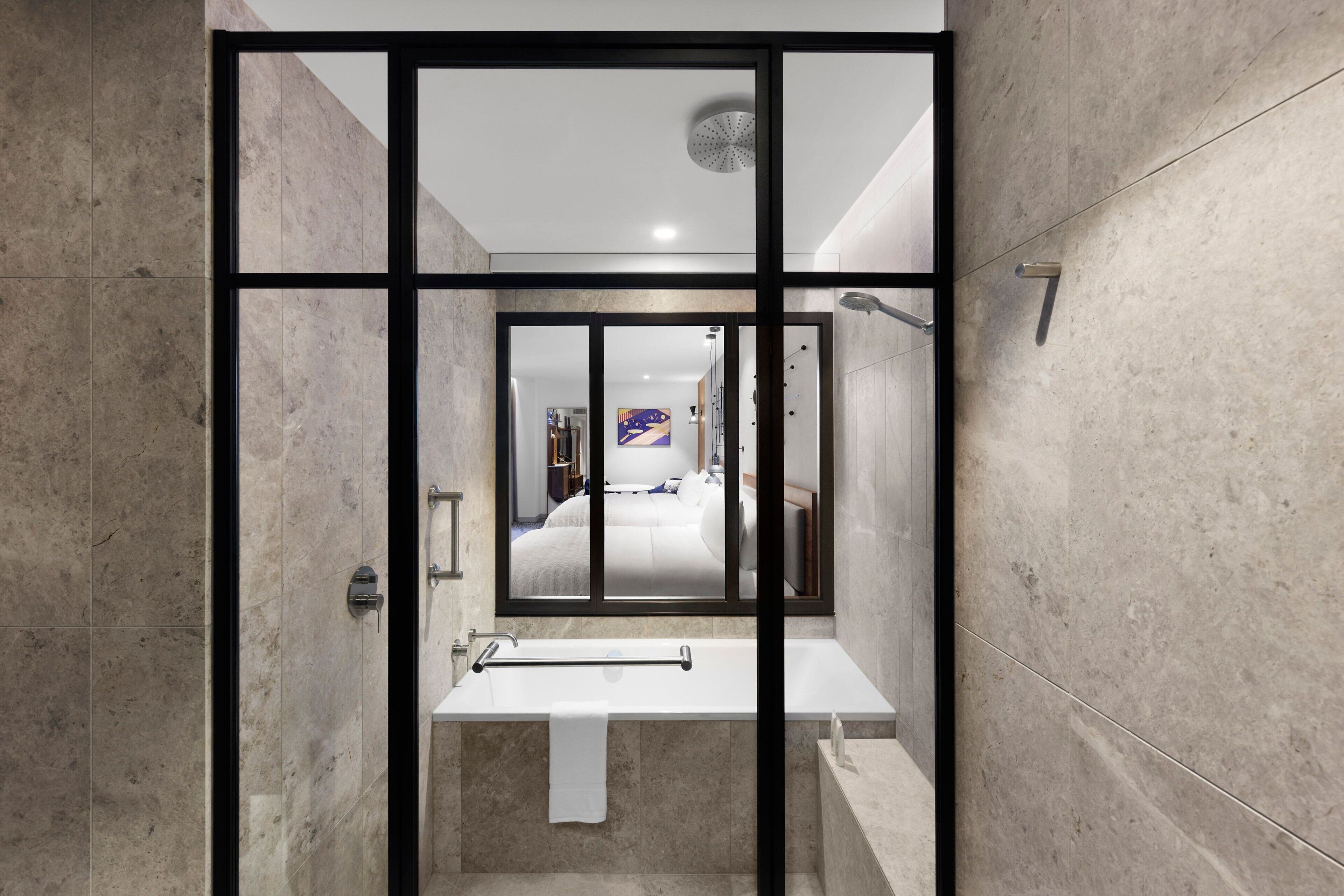 Une salle de bain moderne avec une paroi de séparation en verre, un lavabo blanc et un espace douche.
