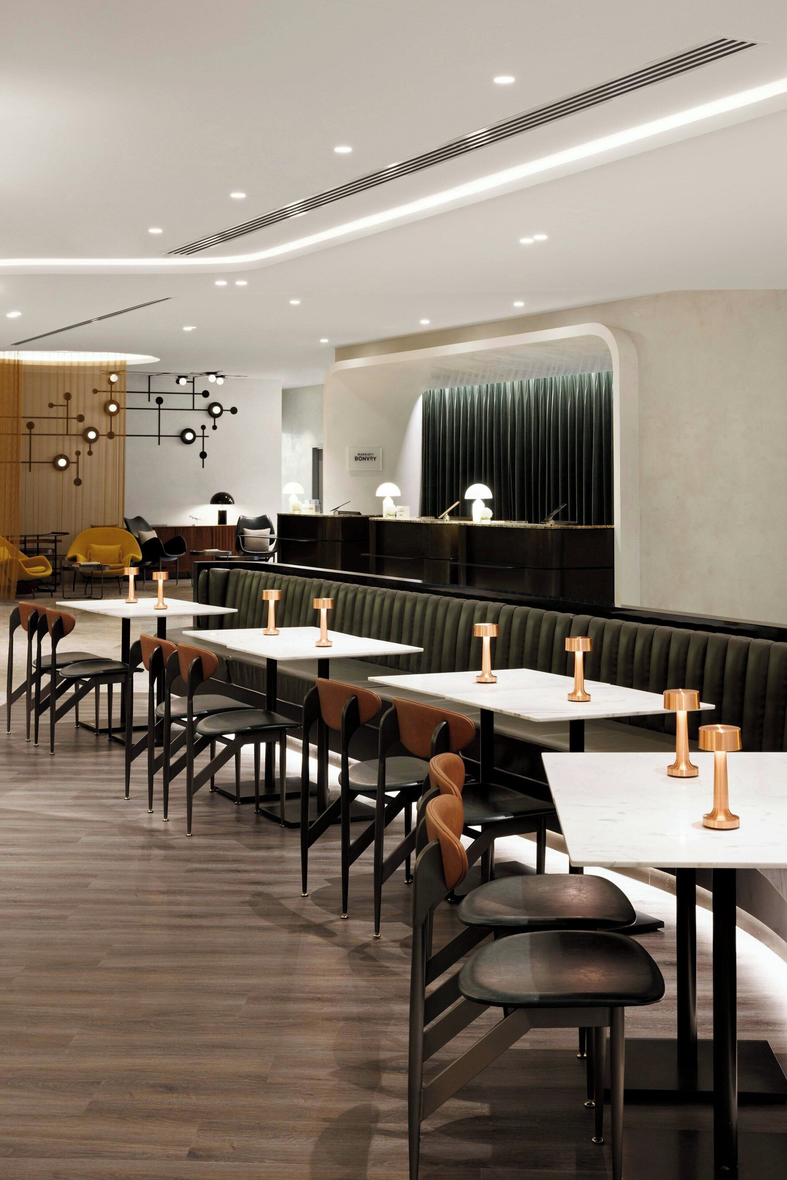 Et moderne restaurantmiljø med båse og borde, indbygget belysning og tidssvarende indretning.