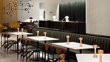A modern restaurant interior with booths and tables, recessed lighting, and contemporary decor.