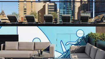 Una piscina al aire libre, sombrillas, sillones reclinables de piscina