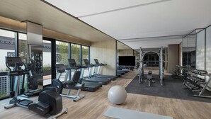 Un gimnasio moderno con cintas de correr, elípticas y pesas libres.