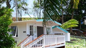 A single-story house with a white exterior, a wooden staircase, and a small porch. - La Mer Luxury Villa - 3 bdrm with sea view & private pool (Cap Estate)