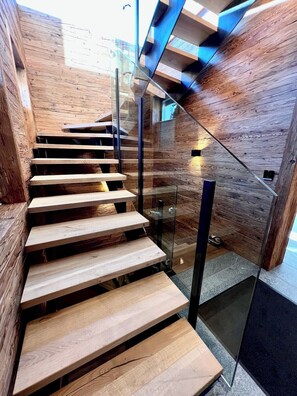Un escalier moderne avec des marches en bois et des rampes en verre.