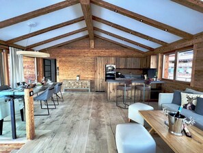 A spacious interior with a dining area, kitchen, and seating space.