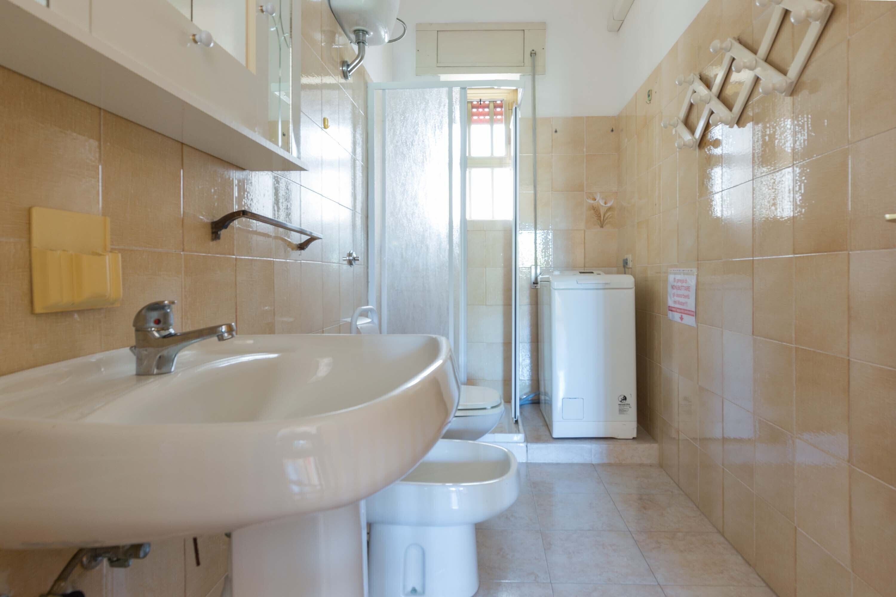 A bathroom with a sink, toilet, and shower.
