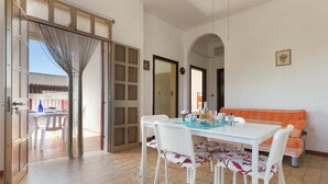 An open-plan living area with a dining table, chairs, and a sofa. - 3149 Villa Giovì - Appartamento 1 by Barbarhouse (Manduria)