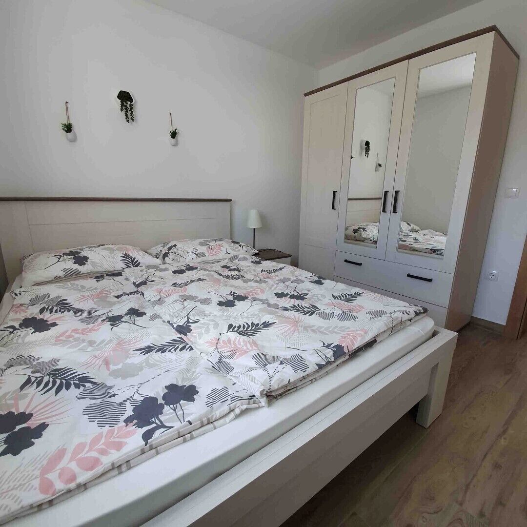 A bedroom with a bed, a wardrobe, and wall-mounted decorations.