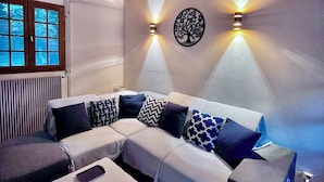 A modern living room with a sectional sofa, a coffee table, and two wall-mounted lights.