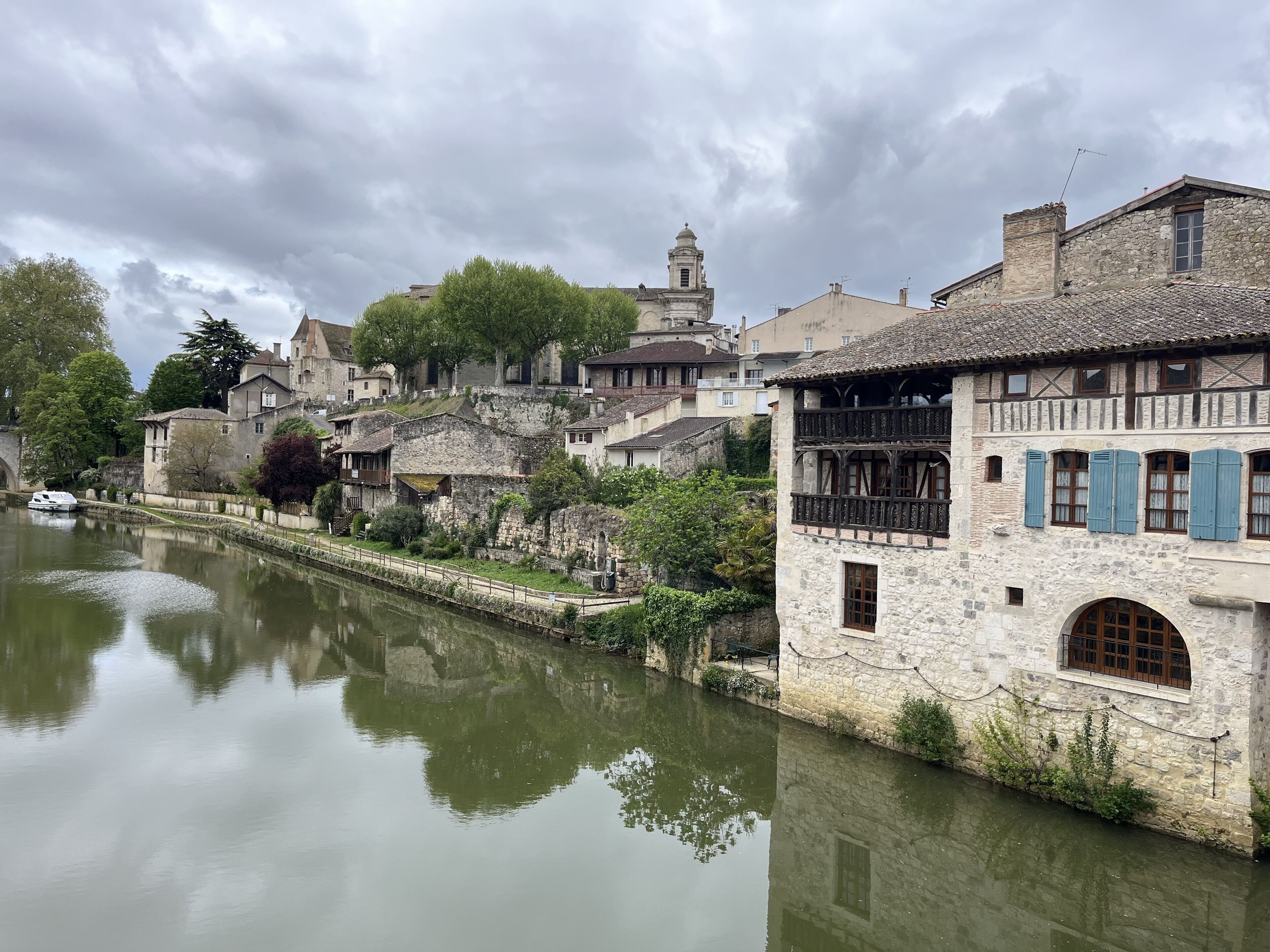 Eine historische Stadt mit Steinhäusern, einem Fluss und einem Turm.