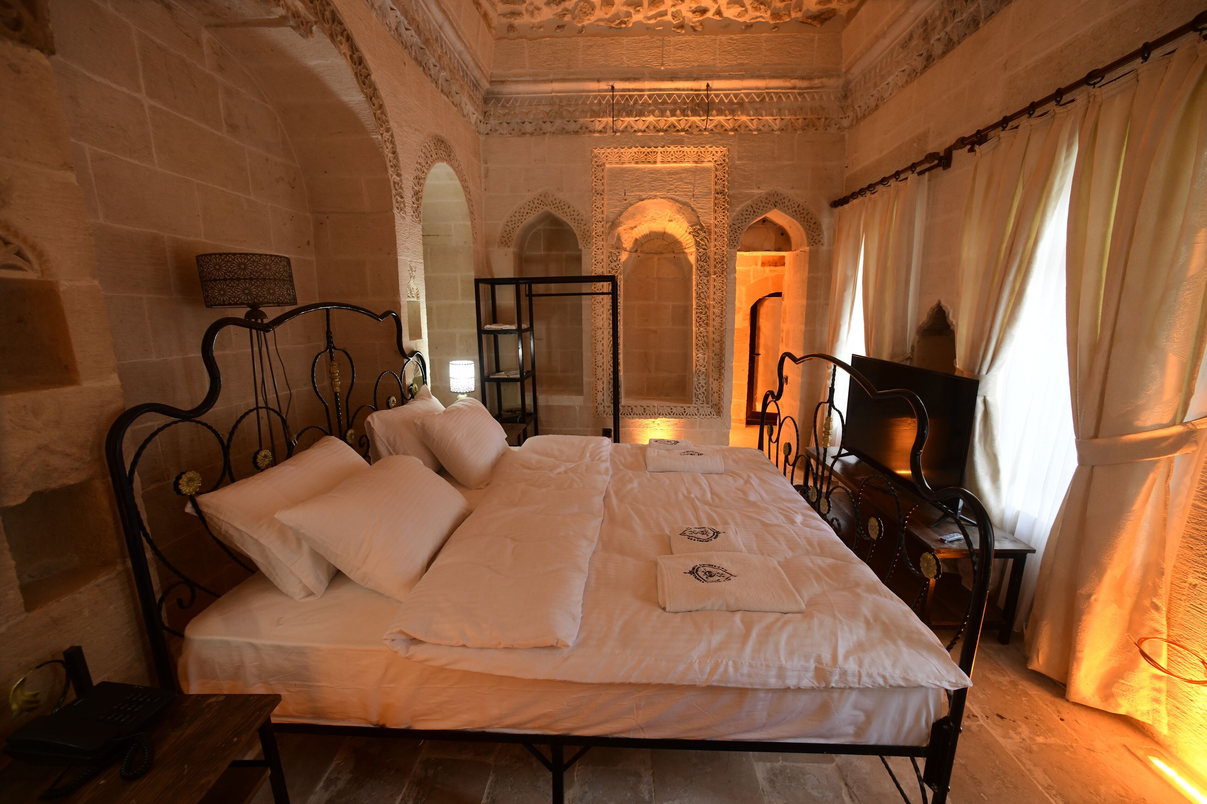 A room with a bed, a desk, and a lamp.