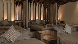 A modern interior with a unique ceiling design, multiple seating areas, and a minimalist aesthetic. - Apartment "Wohnung 2" with Mountain View, Heated Pool & Wi-Fi (Riffiano)