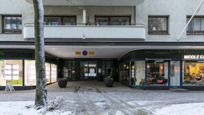 Un bâtiment à la façade plate, doté de grandes fenêtres et d’une enseigne indiquant un espace de stationnement.