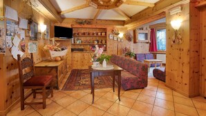 Un intérieur en bois comprenant un canapé, une table, une chaise et un téléviseur.