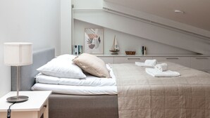 Een moderne slaapkamer met een bed, nachtkastje, lamp en uitzicht op de stadshemel.