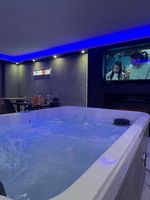 Una habitación con una bañera grande, una pantalla de televisión y un letrero que dice 'LA CASA DE LOVE'.