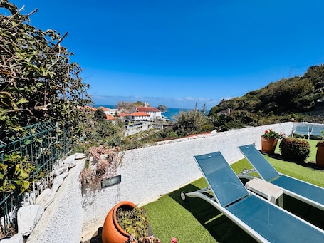 A rooftop terrace with lounge chairs, a view of the sea, and a white building with a red roof.. Studio Matilde and Joaquim, panoramic sea view