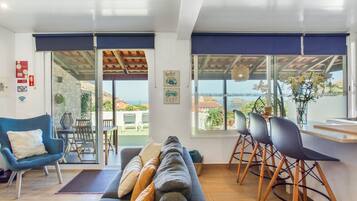 A modern living room with a sofa, chairs, and a dining area.