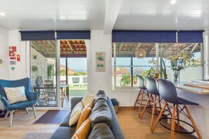 A modern living room with a sofa, chairs, and a dining area. - Villa Matilde e Joaquim, Sea View and Nature (Porto da Cruz)