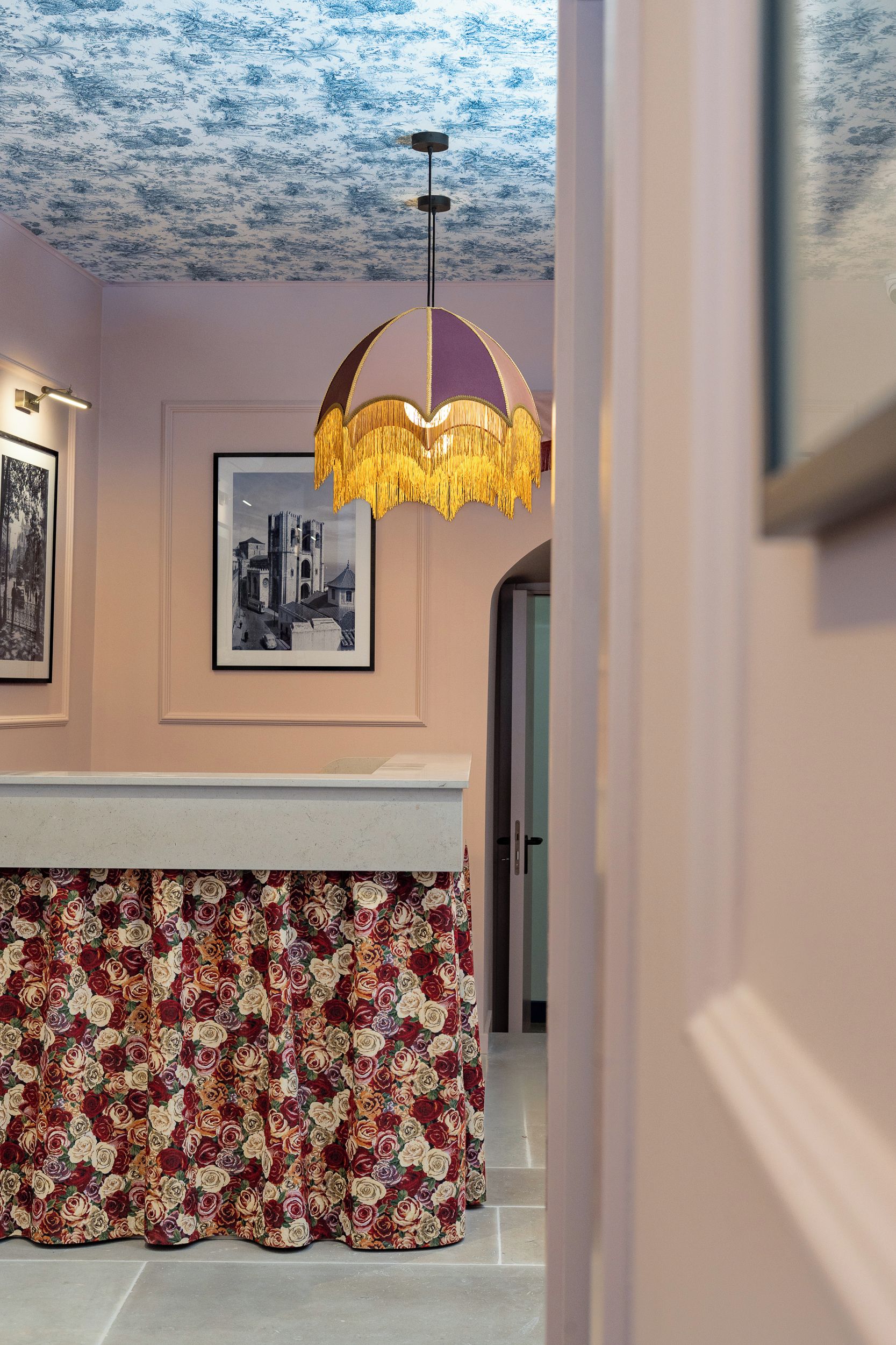 A room with a patterned ceiling, a hanging light fixture, and a framed picture on the wall.