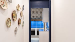 A hallway with a kitchen area visible through an open door. - Succeed Terreiro do Paço Suites (Lisbon)